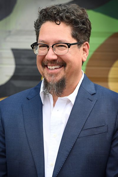  Headshot of Paul Ramos, CEO of Ridiculous Engineering, smiling and wearing glasses and a blue suit with a white shirt.